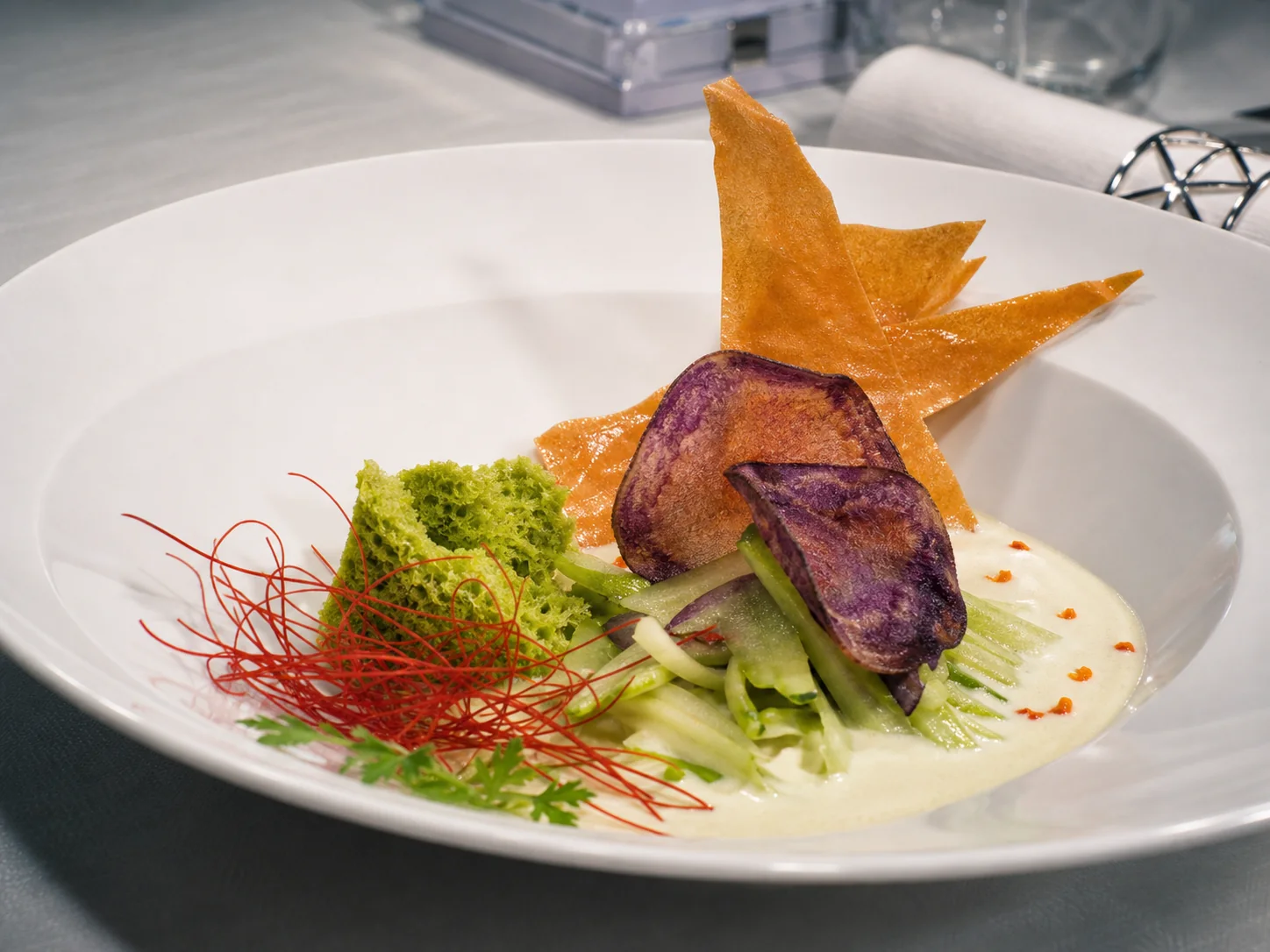 Secondo con verdure verdi, chips croccanti e crema chiara